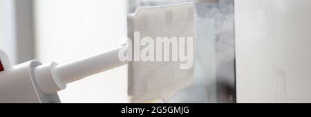 Mop con vaporiera lavando le facciate dei mobili closeup Foto Stock