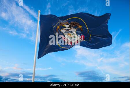 Bandiera dello Utah a cielo nuvoloso su sfondo al tramonto. Concetto patriottico sullo stato. illustrazione 3d, Foto Stock
