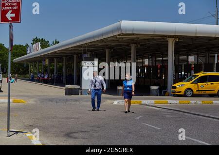 Antalya, Turchia: 26 maggio 2021: Persone mascherate che lavorano all'aeroporto e taxi giallo. Giorno luminoso e soleggiato. Viaggiare durante una pandemia. Foto di alta qualità Foto Stock