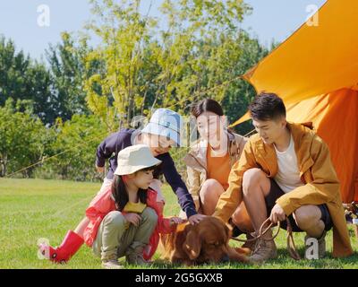 Felice famiglia di quattro e cane da compagnia nel parco foto di alta qualità Foto Stock