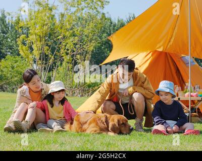 Felice famiglia di quattro e cane da compagnia nel parco foto di alta qualità Foto Stock
