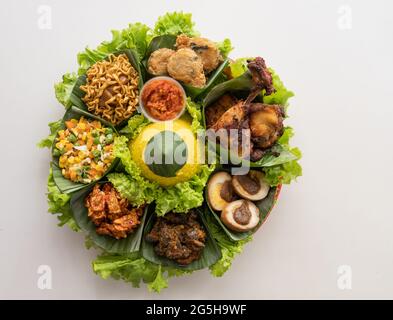 nasi tumpeng. cucina indonesiana riso giallo su foglia di banana Foto Stock