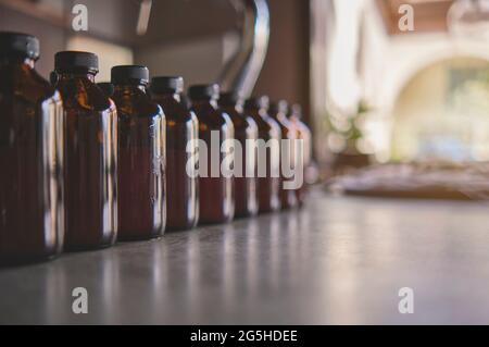 Fila di vari flaconi di medicina marrone senza copyspace etichetta disegno modello. Messa a fuoco selettiva. Foto Stock