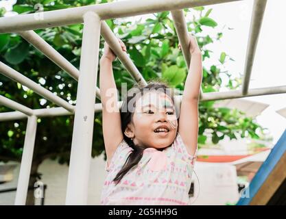 ragazza sana appesa su un bar nel parco giochi Foto Stock