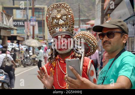 RISHIKESH, INDIA - 28 aprile 2017, Ritratto dell'uomo indiano con il trucco della divinità indù Hanuman, il dio delle scimmie intratterrà la gente sulla strada in Uttarakhand, Foto Stock