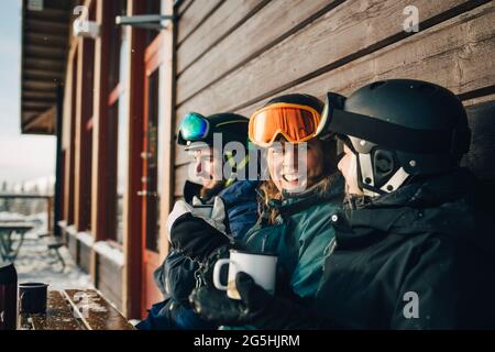 Felici amici di sesso maschile e femminile che trascorrono il tempo libero mentre si beve un caffè nella stazione sciistica Foto Stock