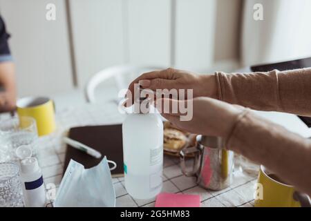 Immagine ritagliata di una donna che disinfetta le mani con disinfettante durante la pandemia Foto Stock