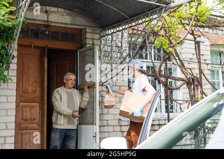 Alimentari alimentari Shopping Aiuto per anziano Senior in piedi a porta. Foto Stock