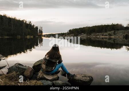 Vista posteriore della giovane escursionista che ammira il lago durante la vacanza Foto Stock