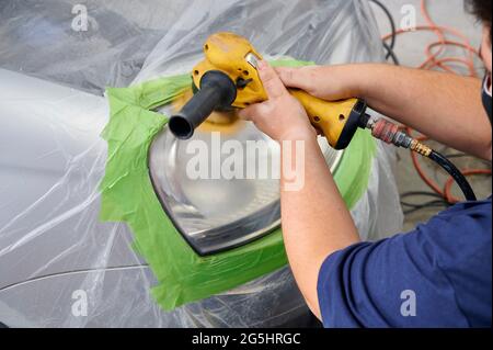 Mechanic la mano di lucidatura è la vettura del faro. Foto Stock