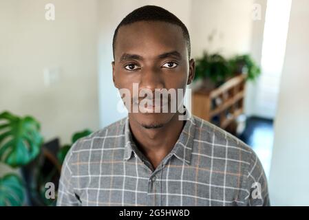 Giovane uomo d'affari africano sicuro in piedi a casa durante una pausa Foto Stock