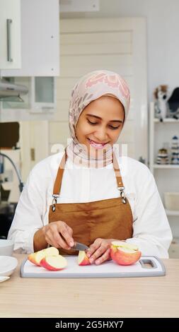 Casalinga Asiatica che indossa Hijab preparare cibo in cucina Foto Stock