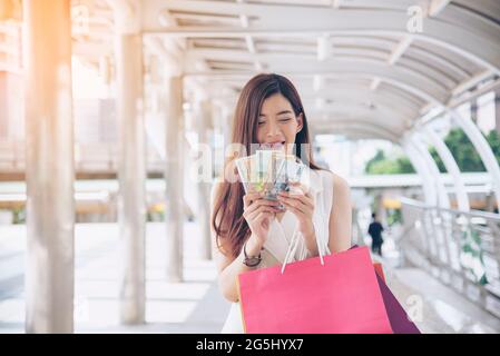 Donne pazzo shopaholic tenendo borse di shopping, soldi, persona di carta di credito a shopping makets.Fashion Donna amore sito online con tag di vendita su Bla Foto Stock