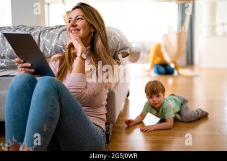 Occupato a lavorare la madre di non avere tempo per il suo bambino Foto Stock