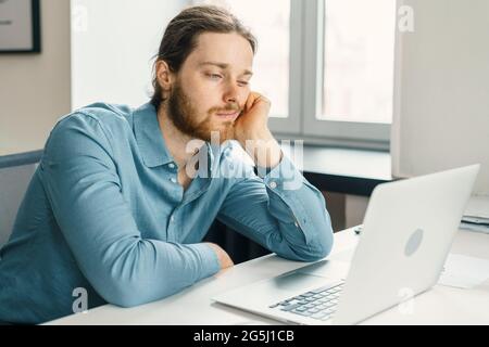 Infelice lavoratore di ufficio maschile si sente annoiato al lavoro Foto Stock