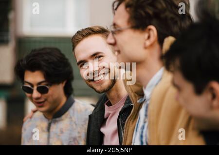 Felice giovane uomo con amici maschi Foto Stock