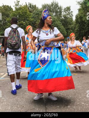 I partecipanti ballano in costumi di carnevale afro caraibico, Notting Hill Carnival, Londra, Inghilterra, Regno Unito Foto Stock