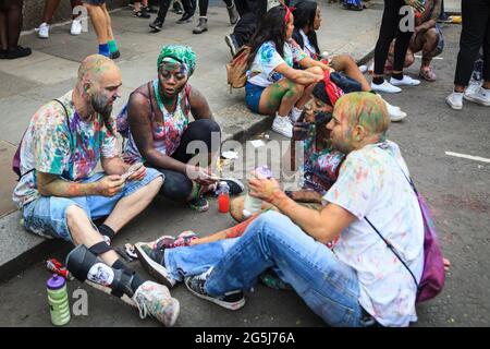 I festaioli potranno godersi la mattina di J'ouvert con la vernice per il viso e la polvere colorata, il Notting Hill Carnival, Londra, Inghilterra Foto Stock