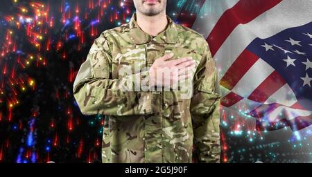Composizione di un soldato maschio con mano a cuore, sopra bandiera americana e fuochi d'artificio Foto Stock