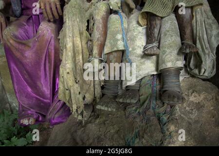 Sotto parti di sculture in legno, rappresentazione (effigie) del popolo defunto, che tradizionalmente chiamato "tau tau", all'interno di una piccola grotta a Kete Kesu, Toraja settentrionale, Sulawesi meridionale, Indonesia. Foto Stock