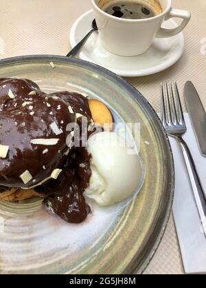 tazza di caffè e torta al cioccolato con gelato sul tavolo Foto Stock