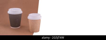 Due tazze da caffè monouso in carta artigianale. Banner con sfondo bianco. Concetto di protezione ambientale. Foto Stock