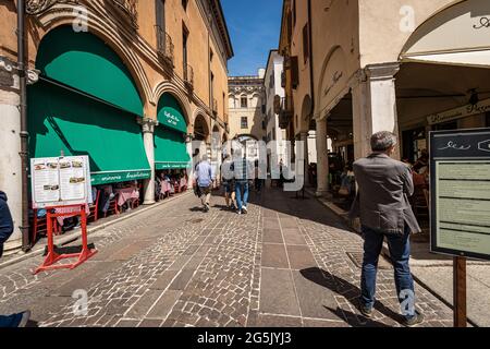 Ristoranti e Pizzerie in Mantova, Lombardia, Italia, Europa. Molte persone hanno il pranzo seduto sotto i portici della strada nel centro. Foto Stock