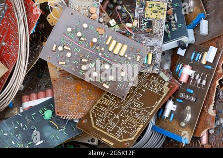 Cumulo di vecchie schede di parti hardware elettroniche usate d'epoca. Componenti elettronici di consumo condensatori di vari componenti elettronici. Riciclaggio elettronico w Foto Stock