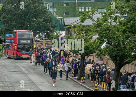 WIMBLEDON LONDRA 28 giugno 2021. Lunghe file di tifosi di tennis che si accodano sotto la pioggia al mattino per entrare nei campi prima dell'inizio del gioco il giorno uno delle navi Wimbledon Championshionship. Il torneo dell'anno scorso è stato annullato a causa della pandemia del Covid-19 per la prima volta dalla seconda guerra mondiale e si svolgerà dal 28 giugno al 11 luglio con una capacità ridotta del 50% e saranno ammessi solo gli spettatori con biglietti preordinati e non sarà consentito fare la coda o il campeggio. Credit amer Ghazzal/Alamy Live News Foto Stock