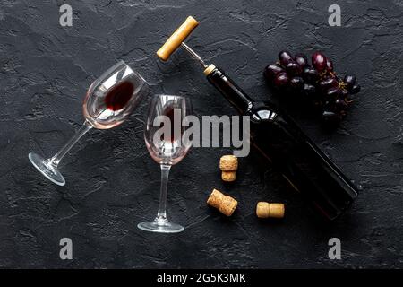 Bottiglia di vino rosso con cavatappi e bicchieri. Vista dall'alto Foto Stock