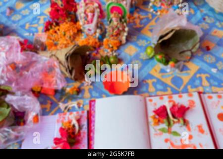 Immagine offuscata della dea Laxmi, Dio Ganesh e nuovo libro di conti per il nuovo anno, sono in adorazione con il fiore e vari altri materiali su auspici Foto Stock