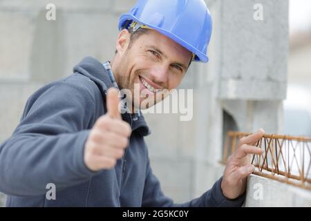 gioioso costruttore mostra pollici in su Foto Stock