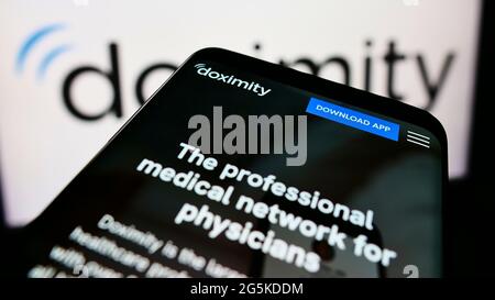 Cellulare con pagina web della piattaforma medica americana di rete Doximity Inc. Su schermo davanti al logo. Mettere a fuoco in alto a sinistra del display del telefono. Foto Stock