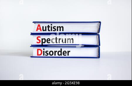 ASD, simbolo di disturbo dello spettro autistico. Libri con parole 'ASD, disturbo dello spettro autistico'. Splendido sfondo bianco. Medico e ASD, spettro autismo d Foto Stock