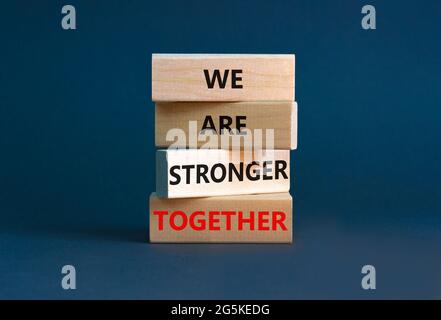 Simbolo di Unione più forte. Blocco di legno con le parole 'siamo più forti insieme'. Splendido sfondo grigio. Mano uomo d'affari. Spazio di copia. Business, motivo Foto Stock