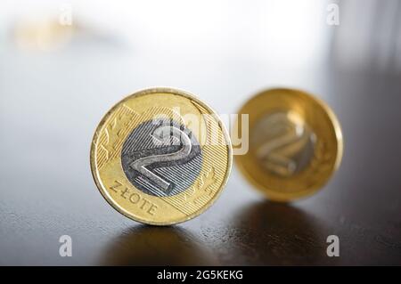 Closeup di due monete polacche zloty in piedi sulla linguetta di legno Foto Stock