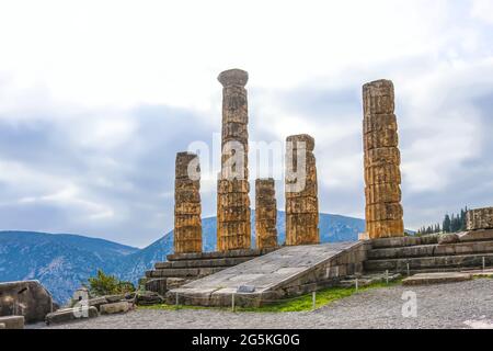 Le colonne ricostruite del Tempio di Apollo a Delphi Grecia si affacciano sulla valle con montagne lontane nel giorno della nebbia Foto Stock