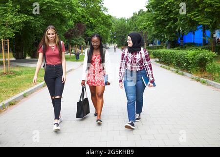 Tre amici che esplorano il loro campus universitario Foto Stock