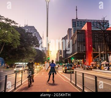 Donna che cavalcano pattini a rotelle sulla pista ciclabile Avenida Paulista Foto Stock