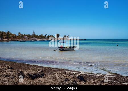 Splendida vista sulla costa mediterranea con acqua di betulla, spiaggia di sabbia bianca e barca da pesca Foto Stock