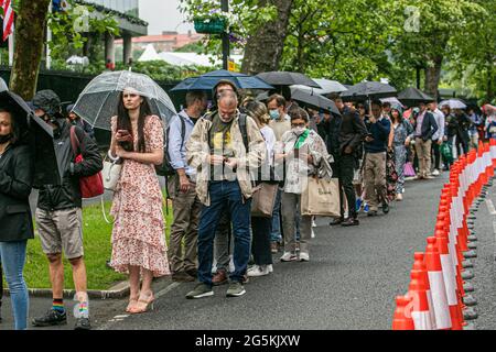 WIMBLEDON LONDRA 28 giugno 2021. Lunghe file di tifosi di tennis che si accodano sotto la pioggia al mattino per entrare nei campi prima dell'inizio del gioco il giorno uno delle navi Wimbledon Championshionship. Il torneo dell'anno scorso è stato annullato a causa della pandemia del Covid-19 per la prima volta dalla seconda guerra mondiale e si svolgerà dal 28 giugno al 11 luglio con una capacità ridotta del 50% e saranno ammessi solo gli spettatori con biglietti preordinati e non sarà consentito fare la coda o il campeggio. Credit amer Ghazzal/Alamy Live News Foto Stock