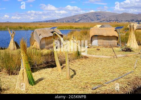 Fasci di lamine di fronte a capanne a canna con celle solari su un'isola galleggiante dell'uro, lago Titicaca, provincia di Puno, Perù, Sud America Foto Stock