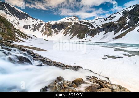 Lago di montagna, in parte congelato, Großglockner alta strada alpina, Hohe Tauern Parco Nazionale, Carinzia, Austria, Europa Foto Stock