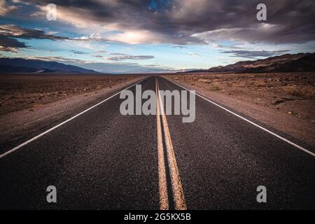 Solitario desolato strada si estende fino all'orizzonte, Death Valley National Park Foto Stock