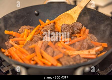 Cucinare pilaf in un calderone. Una ricetta passo dopo passo per cucinare pilaf, tagliare il manzo a pezzi e friggere in un calderone, carne per pilaf.Cooking pilaf a. Foto Stock