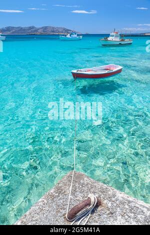 Barche da pesca che riposano presso l'idilliaco porto dell'isola di Koufonisi, in Grecia, con le spettacolari acque turchesi trasparenti. Foto Stock