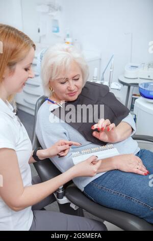 Colpo verticale di una donna anziana che si prepara a ottenere denti sbiancanti presso il suo ufficio dentisti Foto Stock