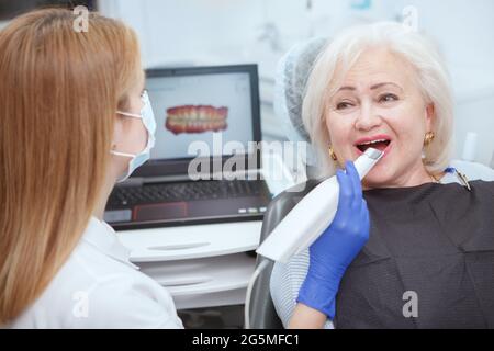 Donna anziana che ottiene la scansione 3d dentale dal suo dentista Foto Stock