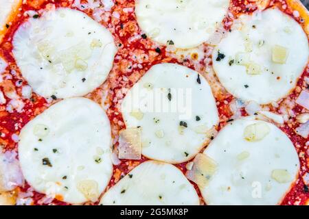 Pizza macro Closeup vista dall'alto della consistenza con mozzarella fusa e cospargere e salsa di pomodoro rosso come cucina italiana Foto Stock