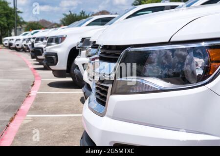 SUV generici bianchi della flotta parcheggiati in un lotto, primo piano laterale sulla parte anteriore del veicolo con attenzione in primo piano. Trasporti e logistica. Foto Stock